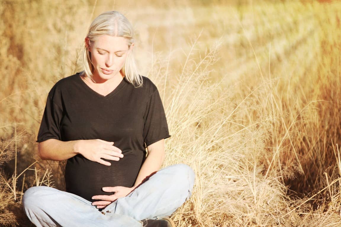 eine schwangere Frau hält ihren Bauch
